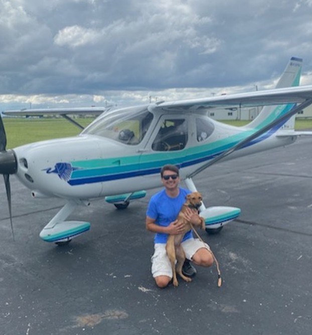 man next to helicopter with dog