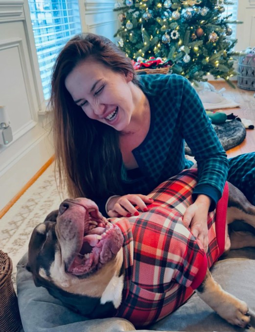 smiling girl playing with pit bull