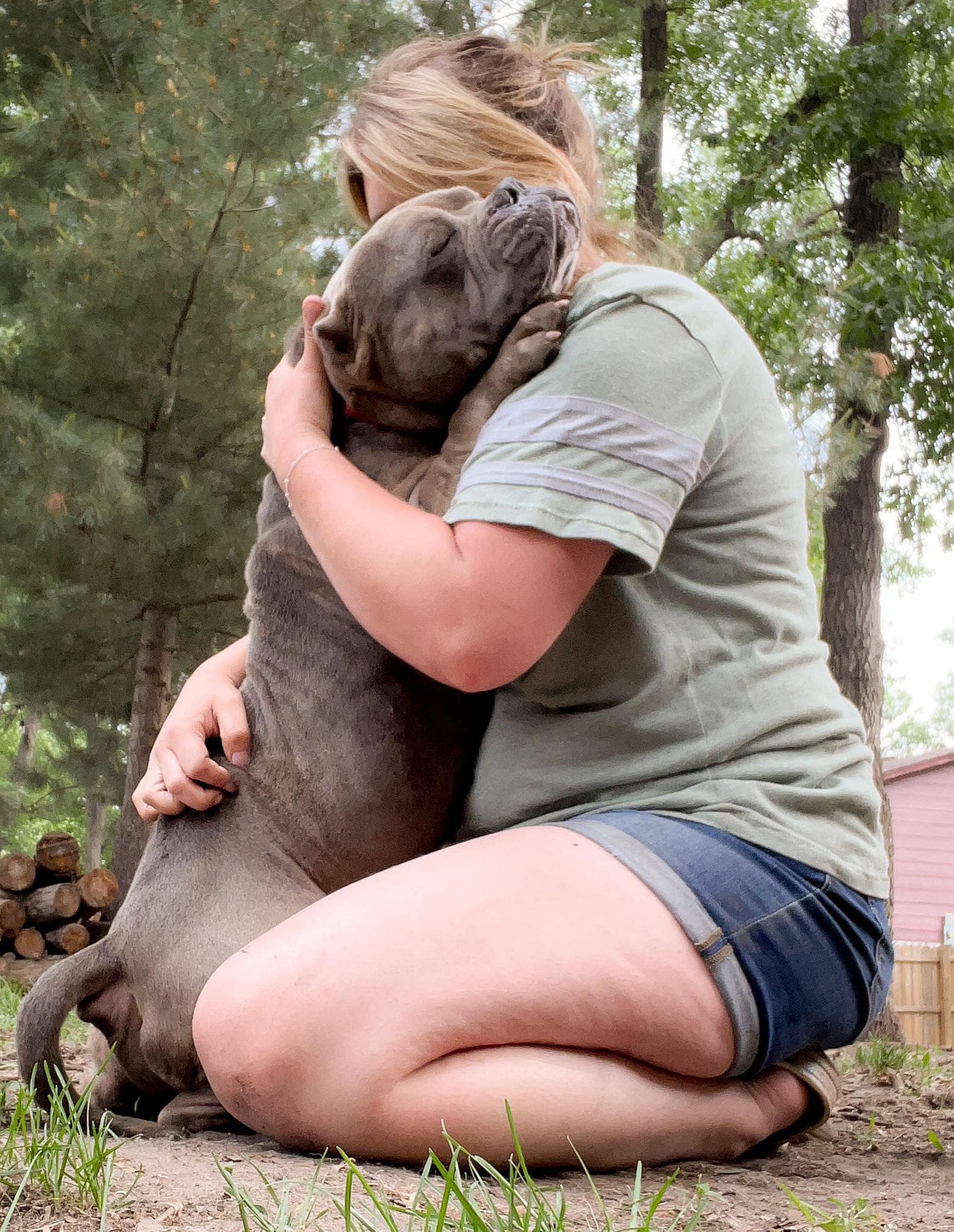 woman hugging a gray dog