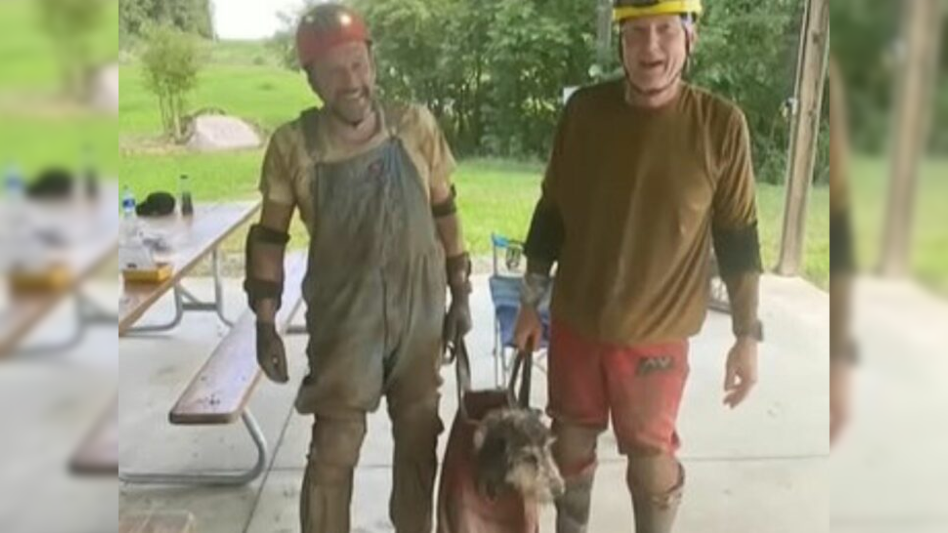 men with dog in bag