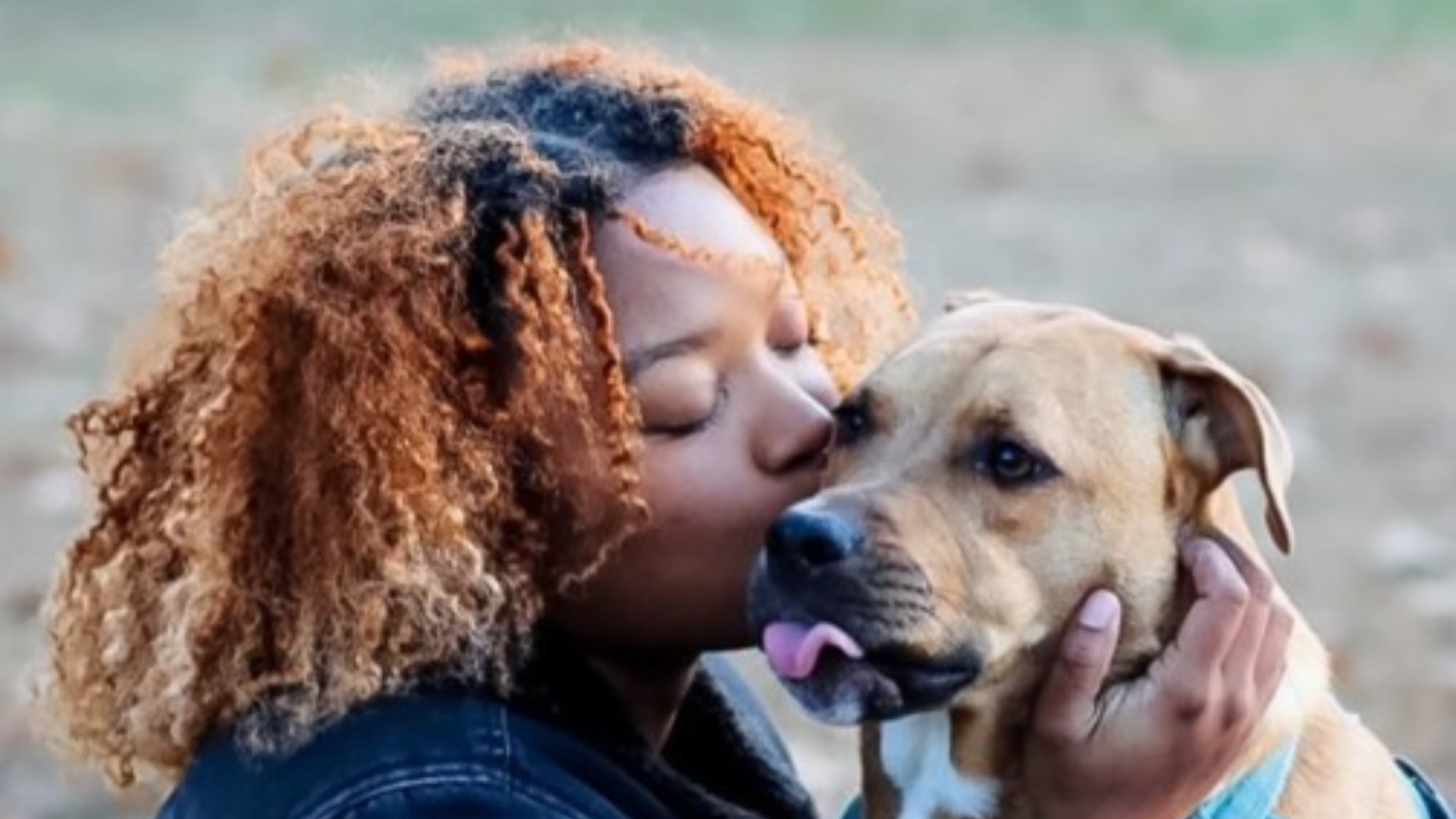 woman kissing dog