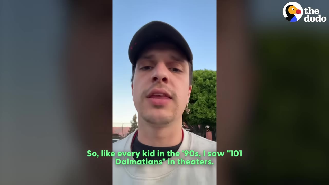 A man wearing a black cap and white shirt speaks to the camera, with green subtitles reading, 'So, like every kid in the '90s, I saw "101 Dalmatians" in theaters.'