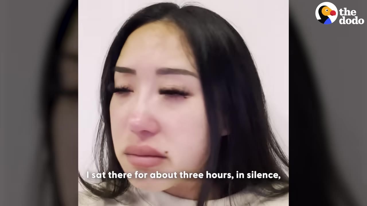 A close-up of a woman with dark hair looking down with a sad, tearful expression, with a subtitle that reads, 'I sat there for about three hours, in silence,'.