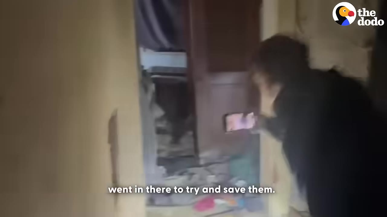 A person holding a phone with its flashlight on enters a messy, derelict room.
