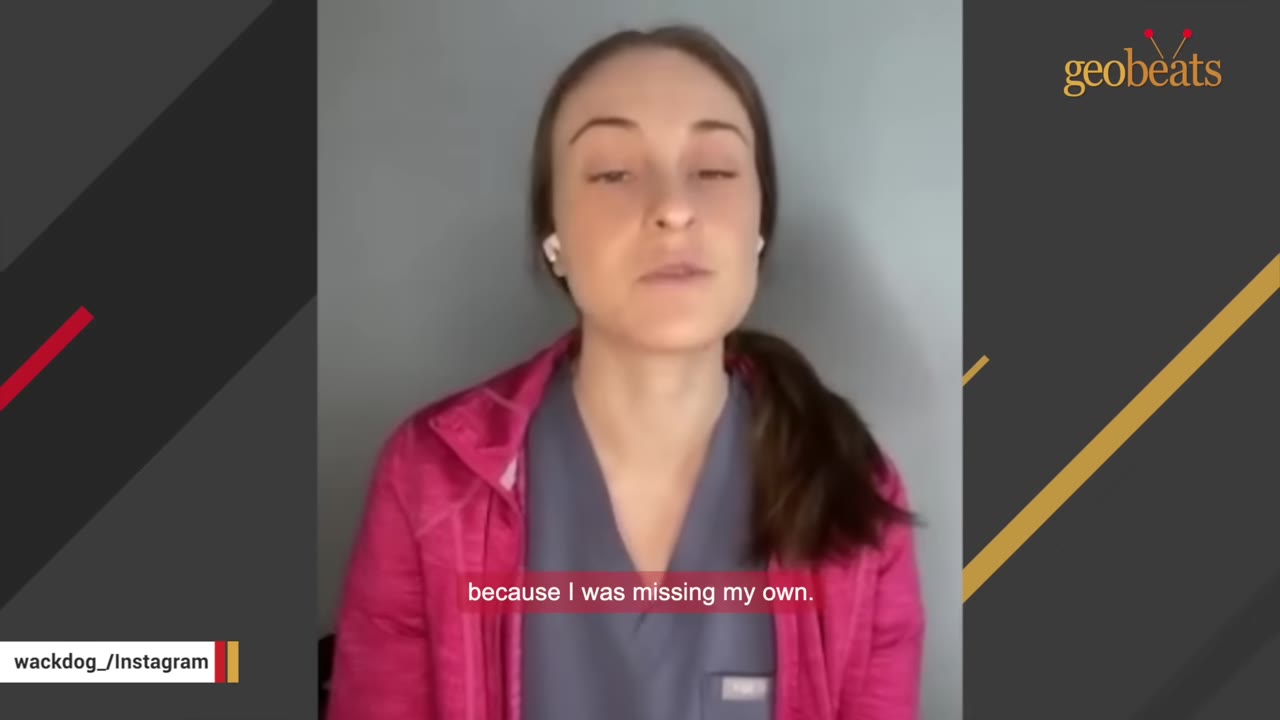 A young woman with brown hair tied back, wearing a pink jacket over blue scrubs, speaking directly to the camera.